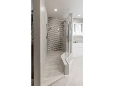Large renovated shower in a new bathroom with a white tile floor