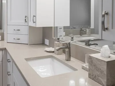 Renovated bathroom with a mirror and tan sink countertops