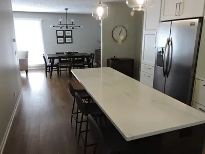 White granite countertop with black chairs in a newly renovated kitchen