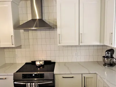 Kitchen remodel with white cabinets and geometric backsplash