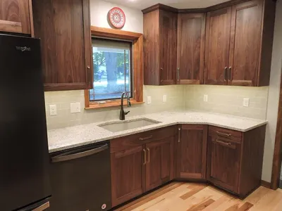 New kitchen with white granite countertops and a black dishwasher