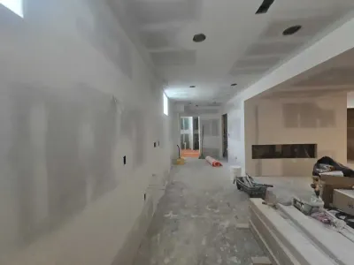 Basement finishing in progress with drywall installation and linear fireplace framing by PaintWerks