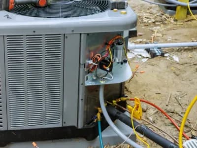 HVAC technician servicing a central air conditioning unit in Utah