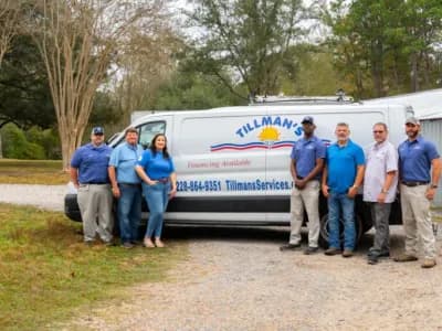 Team of Tillman's heating service professionals standing next to branded service van in Gulfport, MS, showcasing expertise in heating solutions and customer service.