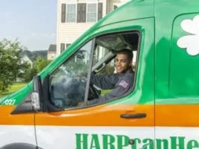 HARP Home Services technician smiling from the repair vehicle