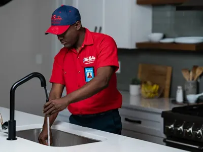 Mr. Rooter professional working on fixing a sink.