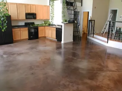 A black refrigerator complements a stylish kitchen and living room upgraded by Paint‑Pro’s.