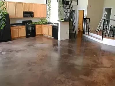 Wood flooring connects an open kitchen and living area refinished by Paint‑Pro’s.