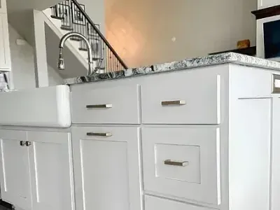 White cabinets and black countertops create a striking kitchen styled by Paint‑Pro’s.
