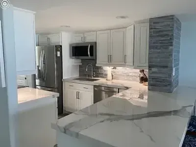 Marble countertops and white cabinets shine in this kitchen updated by Paint‑Pro’s in Ormond Beach, FL.