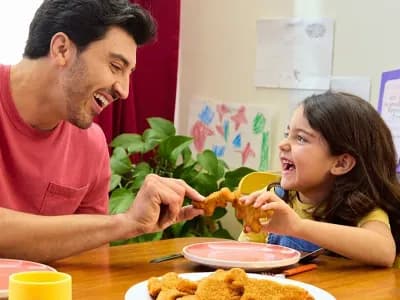 Dad and Daughter eating Tyson Dino Nuggets at Kitchen Table