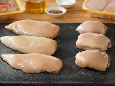 Raw Tyson chicken breast and thighs on cutting board