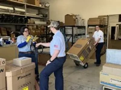Friendly J.A. Bertsch technicians loading and unloading HVAC products in a warehouse setting.