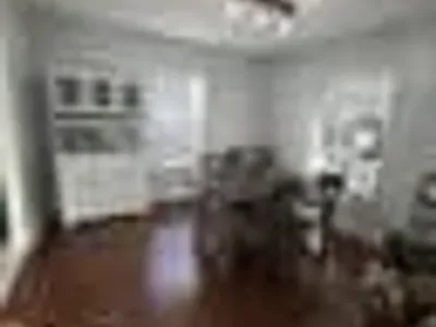 Formal dining room with white wainscoting, dark hardwood floors, and natural light from tall windows painted by OVO Painting in Atlanta