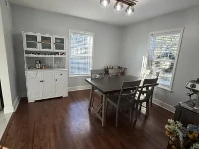 Formal dining room with white wainscoting, dark hardwood floors, and natural light from tall windows painted by OVO Painting in Atlanta