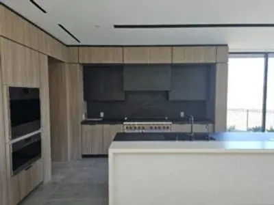 A kitchen with a sink, oven and microwave.