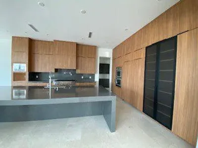Modern kitchen with wood cabinetry and gray island counter.