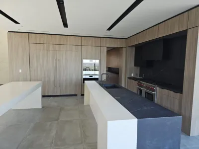 A kitchen with a large counter and a television.