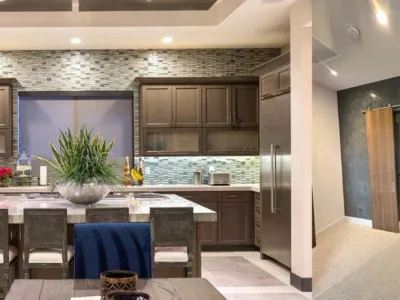 A kitchen with a table and chairs, and a refrigerator.