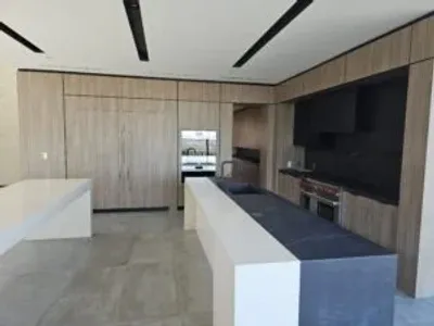 A kitchen with a large counter and a television.
