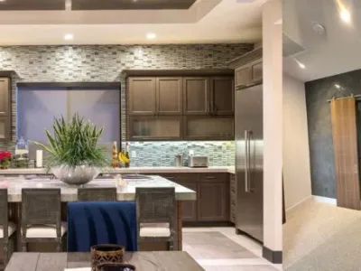A kitchen with a table and chairs, and a refrigerator.