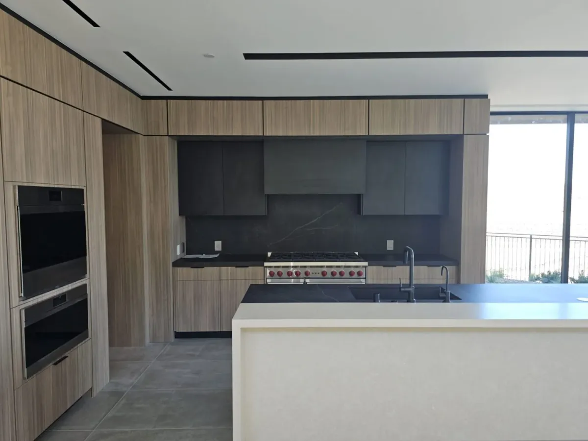 A kitchen with a sink, oven and microwave.