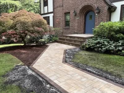 Newly installed paver walkway and steps with lighting leading to a brick home in North Caldwell, Essex County, New Jersey.