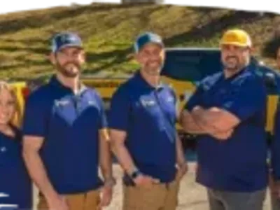 Malone Painting team standing in front of company trucks, smiling and wearing branded polo shirts