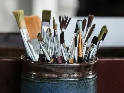 paint brushes in blue container