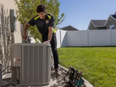 HVAC tech fixing AC unit