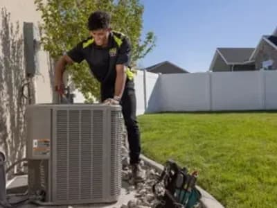 HVAC tech fixing AC unit