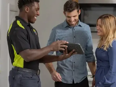 HVAC tech showing tablet to customers