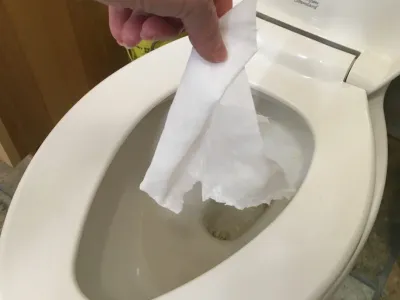 A hand flushing an antibacterial wipe.