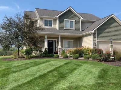 Freshly mowed and mulched Fort Wayne lawn with landscaped shrubs in front of suburban home.